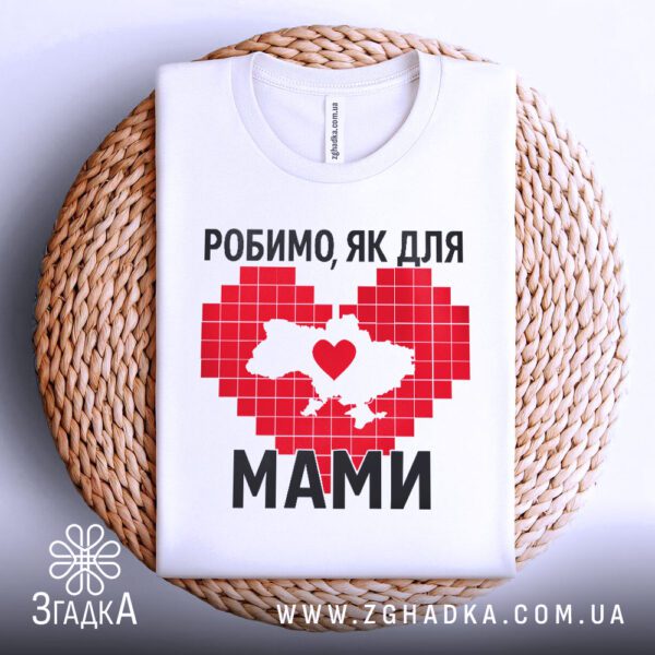 Біла футболка з патріотичним принтом "Робимо, як для мами", складена.