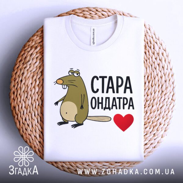 Біла футболка з принтом "Стара Ондатра", складена.