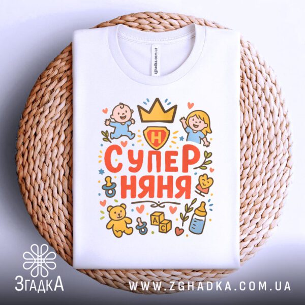 Футболка супер няня подарунок складена на плетеній підставці, крупний план.