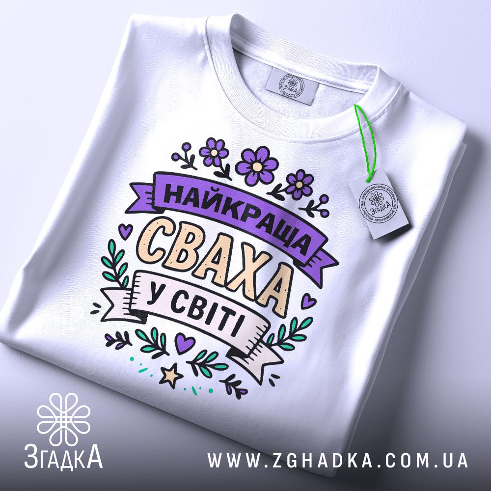 Біла футболка з написом "Найкраща сваха" на манекені збоку.