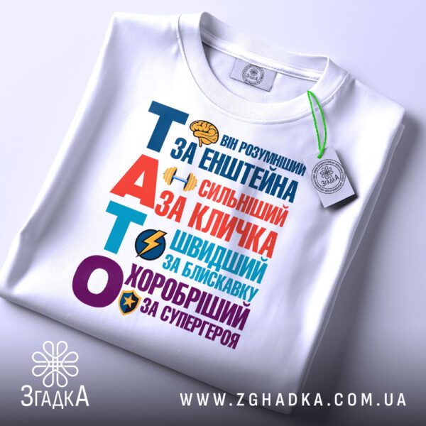 Футболка тато найкращий герой складена з біркою Згадка, добре видно деталі дизайну.