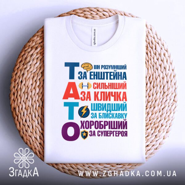 Футболка тато найкращий герой акуратно складена на плетеній підставці.