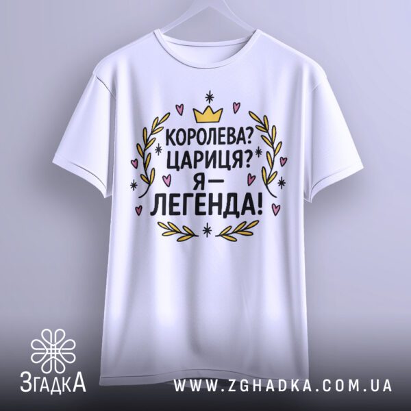 Біла футболка з принтом "Я — легенда" в руці, вид спереду.