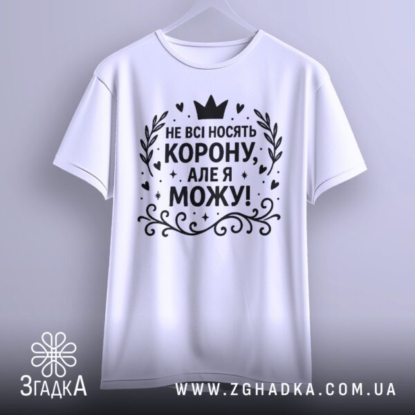 Біла жіноча футболка з принтом "Не всі носять корону", крупний план.