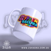 Чашка дурдом веселка для друзів — біла чашка з барвистим принтом у мультяшному стилі.