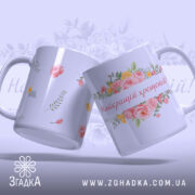 Чашка найкращій хрещеній подарунок. Дві чашки білого кольору, одна з квітковим принтом, інша з дрібними квітами, обидві з глянцевою поверхнею. Ручки стандартної форми, фон ніжно-фіолетовий.