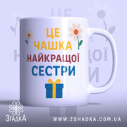 Чашка найкращої сестри подарунок, біла з кольоровим принтом, зображення з фронтального ракурсу, фон світло-фіолетовий, на чашці напис великими літерами: 'ЦЕ ЧАШКА НАЙКРАЩОЇ СЕСТРИ', з квітами та подарунком, ручка кругла, край рівний, глянцева поверхня.
