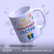 Чашка найкращої сестри подарунок, біла з кольоровим принтом, зображення з бокового ракурсу, фон світло-фіолетовий, на чашці напис великими літерами: 'ЦЕ ЧАШКА НАЙКРАЩОЇ СЕСТРИ', з квітами та подарунком, ручка кругла, край рівний, глянцева поверхня.