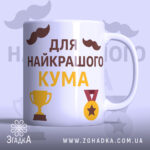 Чашка найкращому куму, біла з глянцевим покриттям, з написом 'для найкращого кума' жовтого та коричневого кольорів, з зображеннями кубка та медалі, ручка гладка, край рівний.