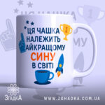 Чашка найкращому сину подарунок. Чашка білого кольору з яскравим принтом, на якому зображено текст синього та оранжевого кольорів. Ручка круглої форми, край рівний, поверхня глянцева. Фон світло-синій з елементами зірок та трофеїв.