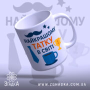 Чашка подарунок для тата. Чашка білого кольору, з легким нахилом, на фоні з градієнтом. Принт містить напис 'НАЙКРАЩОМУ ТАТКУ В СВІТІ' з яскравими елементами, такими як краватка та кубок. Ручка круглої форми, край рівний, поверхня глянцева.