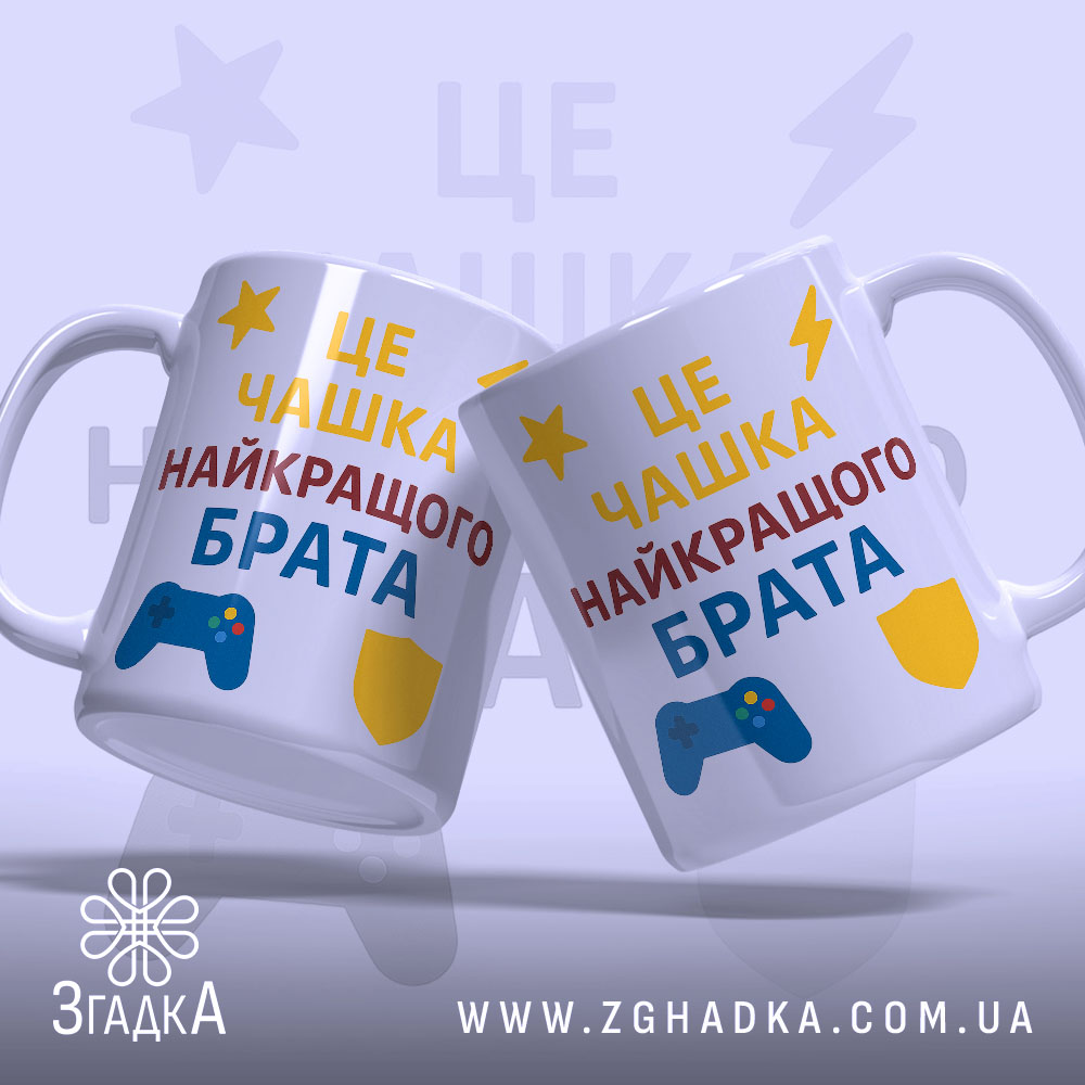 Чашка подарунок улюбленому брату. Дві чашки білого кольору, розташовані під кутом один до одного. На обох чашках один і той же принт з текстом 'ЦЕ ЧАШКА НАЙКРАЩОГО БРАТА' у жовтому, червоному та синьому кольорах. Принти містять ігровий контролер та щит. Ручки стандартної форми, краї гладкі, поверхня глянцева, фон світло-фіолетовий.