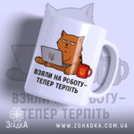 Чашка з жартом про роботу, біла, з ракурсом спереду, на фоні світло-синього кольору, з малюнком кота, що сидить за комп'ютером, і написом 'ВЗЯЛИ НА РОБОТУ – ТЕПЕР ТЕРПІТЬ', ручка кругла, край рівний, матова поверхня.