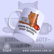 Чашка з жартом про роботу, біла, з ракурсом спереду, на фоні світло-синього кольору, з малюнком кота, що сидить за комп'ютером, і написом 'ВЗЯЛИ НА РОБОТУ – ТЕПЕР ТЕРПІТЬ', ручка кругла, край рівний, матова поверхня.