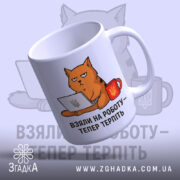 Чашка з жартом про роботу, біла, з ракурсом з правого боку, на фоні світло-синього кольору, з малюнком кота, що сидить за комп'ютером, і написом 'ВЗЯЛИ НА РОБОТУ – ТЕПЕР ТЕРПІТЬ', ручка кругла, край рівний, матова поверхня.