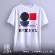 Футболка Будь простіше Простота, біла футболка, підвішена на вішалці, з принтом у вигляді кольорових геометричних фігур: чорного кола, червоного квадрата та синього півкола, текст червоним шрифтом 'Будь простіше!' та чорним 'ПРОСТОТА', фон сірий.