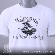 Футболка чарівна на всю голову, білого кольору, зображена з ракурсу спереду на манекені, фон світло-сірий, принт з відьмою на мітлі та зірками.