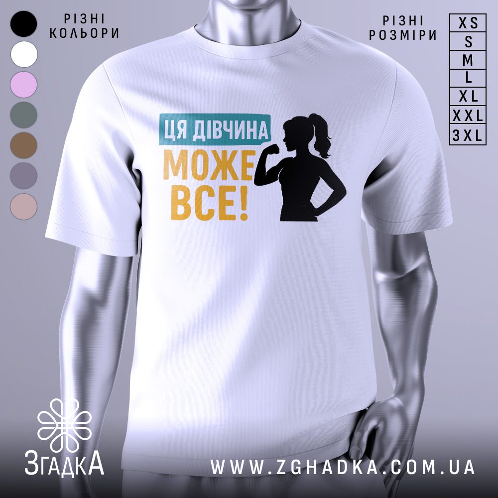 Футболка для підтримки дівчат, білого кольору, зображена на манекені, фон світло-сірий, принт містить текст "ЦЯ ДІВЧИНА МОЖЕ ВСЕ!" у жовтому та блакитному кольорах, а також силует дівчини з піднятою рукою.