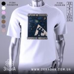 Футболка дрони не сплять, біла, зображена на манекені, фон світло-сірий, принт з дронами, українським гербом та силуетом людини на фоні зірок.