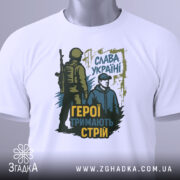 Футболка герої тримають стрій. Біла футболка на манекені, з чітким зображенням принта, що містить військового та цивільного чоловіка, а також патріотичний напис.