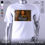 Футболка книгонута на всю голову, білого кольору, з ракурсу спереду, на фоні розмитого сірого кольору, з принтом, що зображує дівчину з книгою на фоні книжкових полиць.