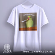 Футболка кому зараз легко, біла, підвішена на вішалці, фон нейтральний, принт з папугою, що тримає сигарету, текст зверху: 'А КОМУ ЗАРАЗ ЛЕГКО'.