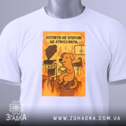 Футболка котлети не згоріли. Біла футболка з принтом, на якому зображений жовтий собака, що сидить на стільці з чашкою в руках. На фоні видно кухонну плиту з димом та вогнем. Футболка зображена з фронтального ракурсу на манекені.