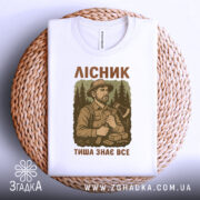 Футболка лісник тиша знає, складена футболка на кошику, ракурс зверху, фон світлий, принт з лісником, текст на футболці.