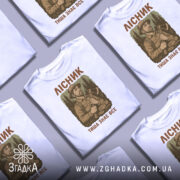 Футболка лісник тиша знає, кілька складених футболок, ракурс зверху, фон світлий, принт з лісником, текст на кожній футболці.