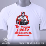 Футболка маєш право відрізнятись. Білий колір, зображена спереду, фон сірий, принт з червоним текстом і чорною ілюстрацією жінки, на манекені.