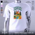 Футболка мандруй і надихайся, біла, з фронтального ракурсу, на манекені, фон світло-сірий, принт з гірським пейзажем, річкою та деревами, кольори яскраві: червоний, зелений, жовтий, блакитний.