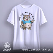 Футболка моє пузо мої правила. Біла футболка, підвішена на вішалці, з принтом кота в блакитній футболці, що усміхається та показує жестом вказівний палець. Фон світло-сірий, деталі принта чітко видимі.