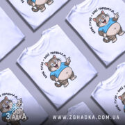 Футболка моє пузо мої правила. Білі футболки, складені в хаотичному порядку, з принтом кота в блакитній футболці, що усміхається. Фон світло-сірий, деталі принта чітко видимі.