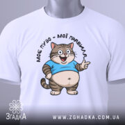 Футболка моє пузо мої правила. Біла футболка на манекені, з принтом кота в блакитній футболці, що усміхається та показує жестом вказівний палець. Фон світло-сірий, деталі принта чітко видимі.
