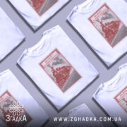 Футболка на повній швидкості, біла, з ракурсу зверху, на фоні світло-сірого, кілька футболок з паровозом в червоному кольорі, оформлені як поштовий штамп.
