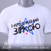 Футболка народжений зіркою подарунок, біла, зображена на манекені, фон однотонний, принт містить текст "НАРОДЖЕНИЙ ЗІРКОЮ" з червоними і синіми зірками.