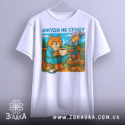 Футболка нікуди не спішу, біла, підвішена на вішалці, фон однорідний, принт з котом у халаті, що п'є з чашки, на фоні природа та дим від заводів.