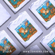 Футболка нікуди не спішу, біла, зображена зверху на декількох футболках, фон світло-сірий, принт з котом у халаті, що п'є з чашки, на фоні природа та дим від заводів.