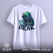 Футболка окак мем подарунок, біла футболка, підвішена на вішалці, з принтом чорного кота в капюшоні, який сидить за ноутбуком, фон світло-сірий.