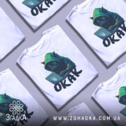 Футболка окак мем подарунок, кілька білих футболок, складених одна на одну, з принтом чорного кота в капюшоні, який працює за ноутбуком, фон світло-сірий.