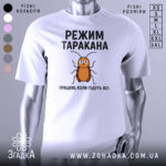 Футболка з принтом таргана, білого кольору, зображена з правого ракурсу на манекені, фон світло-сірий, принт з тарганом та текстом "РЕЖИМ ТАРАКАНА ПРАЦЮЮ, КОЛИ ПІДУТЬ ВСІ".