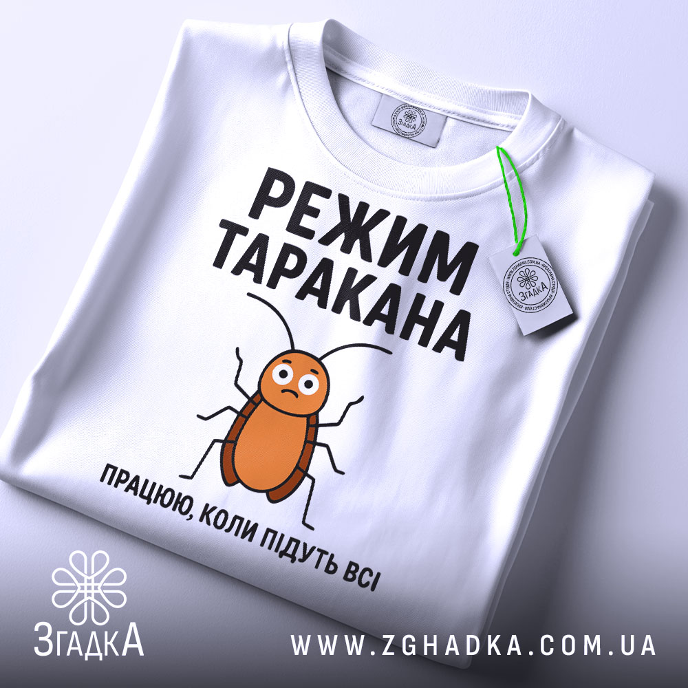 Футболка з принтом таргана, білого кольору, зображена зверху, фон світло-сірий, принт з тарганом та текстом "РЕЖИМ ТАРАКАНА ПРАЦЮЮ, КОЛИ ПІДУТЬ ВСІ", на футболці є етикетка.
