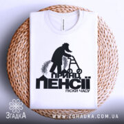 Футболка принц пенсії піски. Біла футболка, складена на плетеній основі, фон світлий, принт чорного кольору, чітке зображення чоловіка на ходунках.