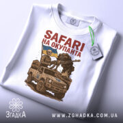 Футболка сафарі на окупанта, біла, зображена з верхнього ракурсу, на столі, фон світло-сірий, принт з військовим у шоломі, що тримає гвинтівку, та автомобілем з українським прапором, з етикеткою.