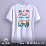 Футболка спілкування з довбойобами, білого кольору, підвішена на вішалці, фон світло-сірий, принт з текстом "СПЕЦІАЛІСТ ПО СПІЛКУВАННЮ З ДОВБОЙОБАМИ" в яскравих кольорах, з іконками телефону та листа.