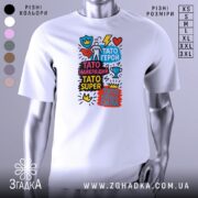 Футболка Тато супер герой, біла, зображена на манекені з правого боку, фон сірий, принт містить яскраві кольорові елементи з написами на українській мові.