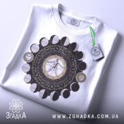 Футболка з астрологічним принтом, білого кольору, складена на поверхні, фон світлий, принт з детальним зображенням астрологічних символів та фази місяця.