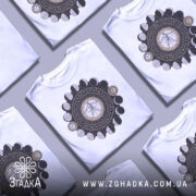 Футболка з астрологічним принтом, білого кольору, складена в декілька шарів, фон світло-сірий, принт містить зображення астрологічних символів та фази місяця.