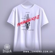 Футболка з автомобільним дизайном, біла, підвішена на вішалці, фон світлий, принт з малюнком свічки запалювання та текстом "Гаражний культ" червоного кольору.