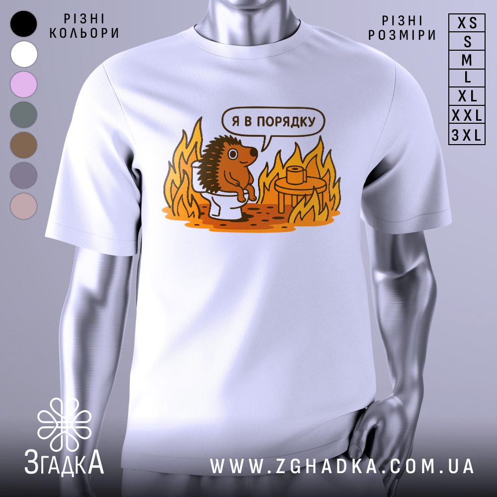 Футболка з їжаком в порядку. Біла футболка з принтом їжака, що сидить на унітазі серед вогню. Принт яскравий, з оранжевими та коричневими відтінками, текст "Я в порядку" над їжаком. Фон світлий, з легким градієнтом.